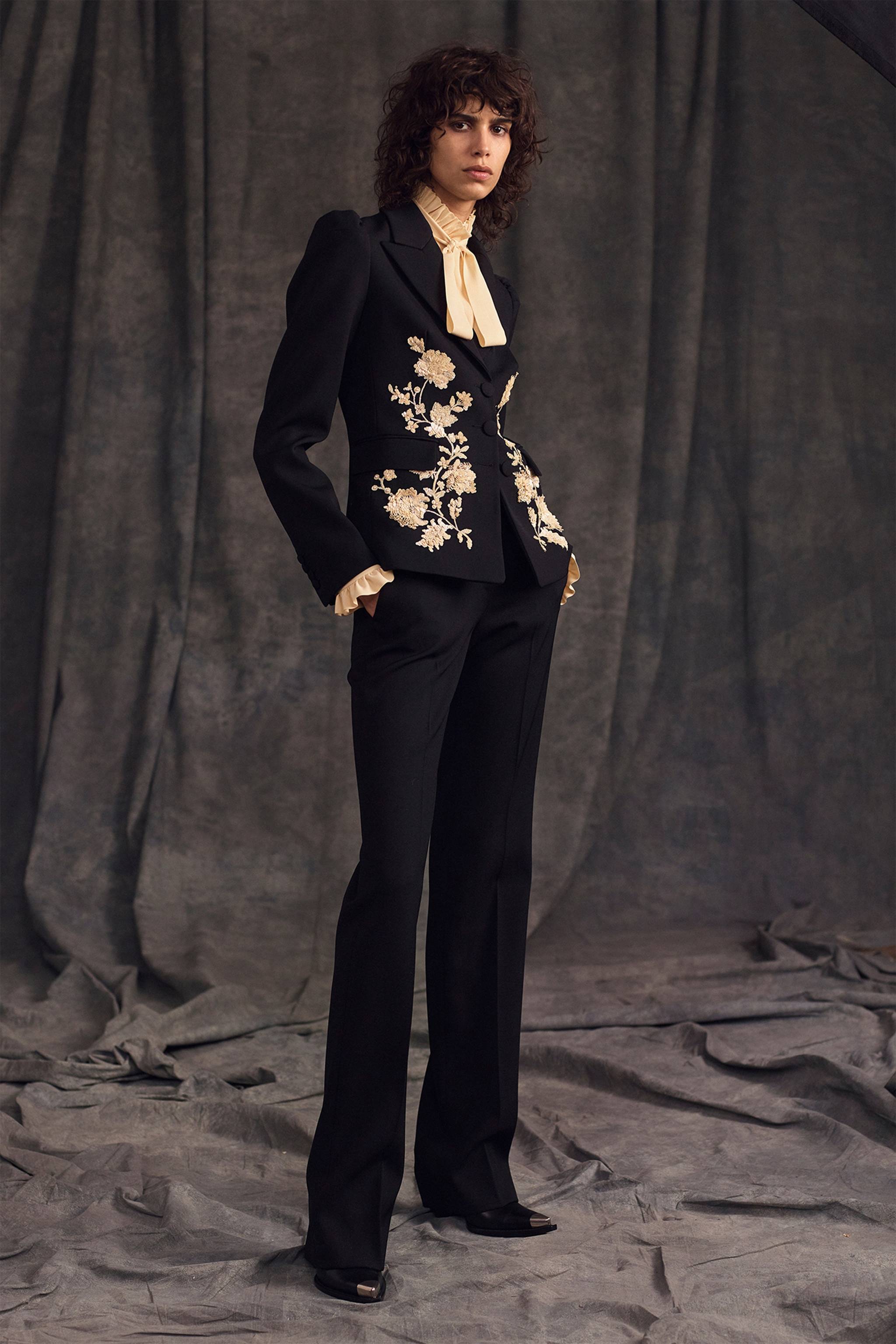Tailleur noir avec broderie de fleurs et chemise à volants de la collection