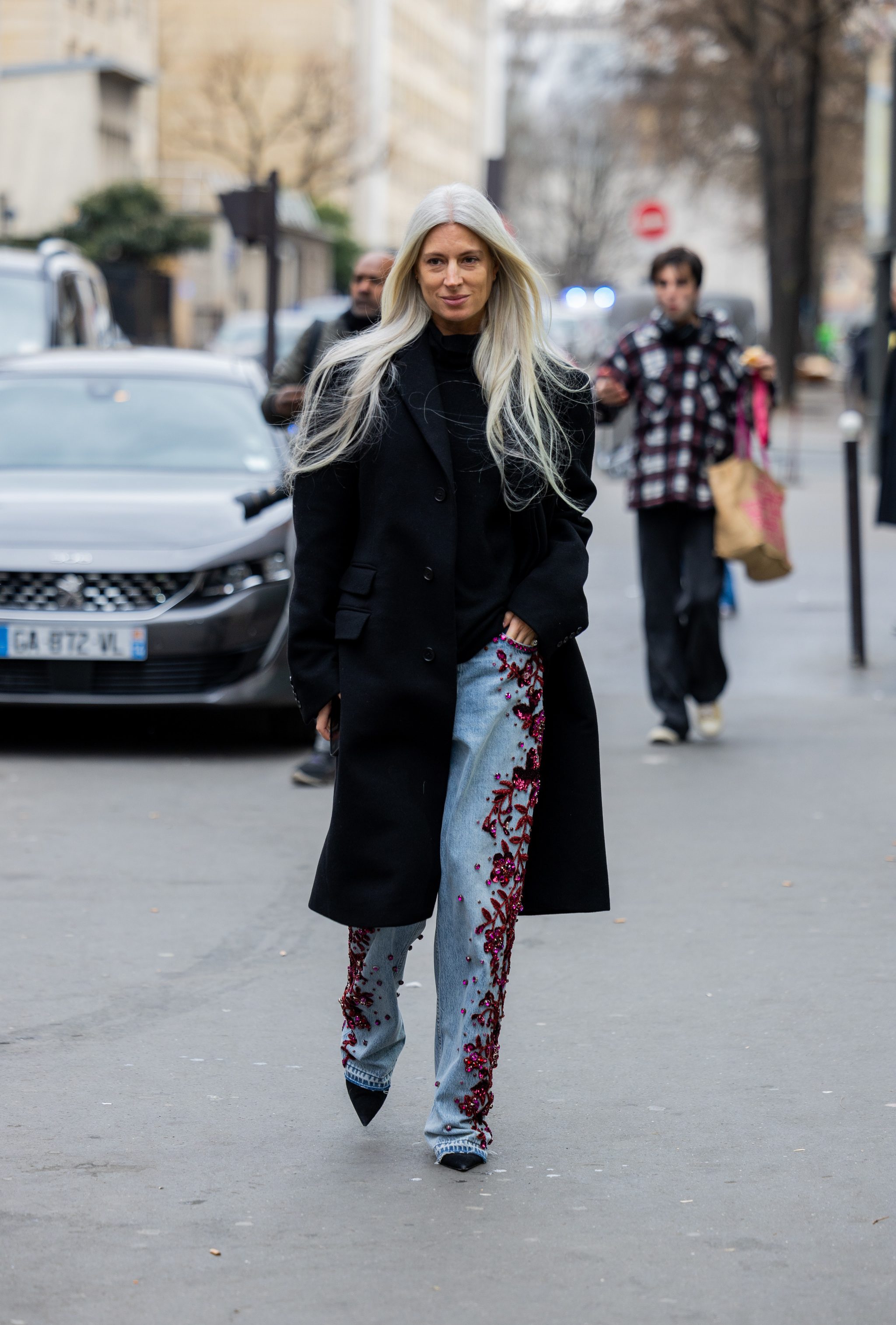 Sarah Harris dans un pull noir et un jean avec broderie de strass.