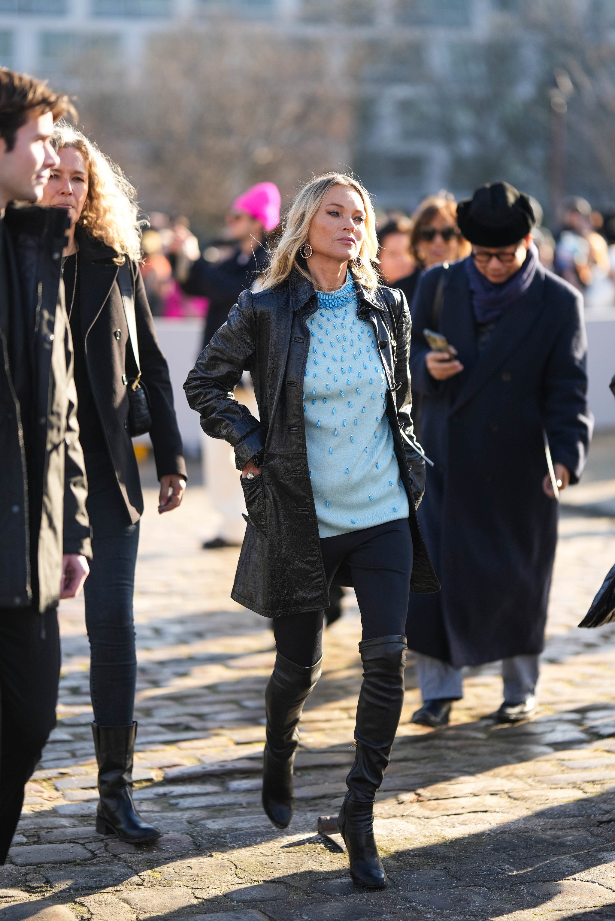 Kate Moss avec des bottes hautes et des leggings noirs.