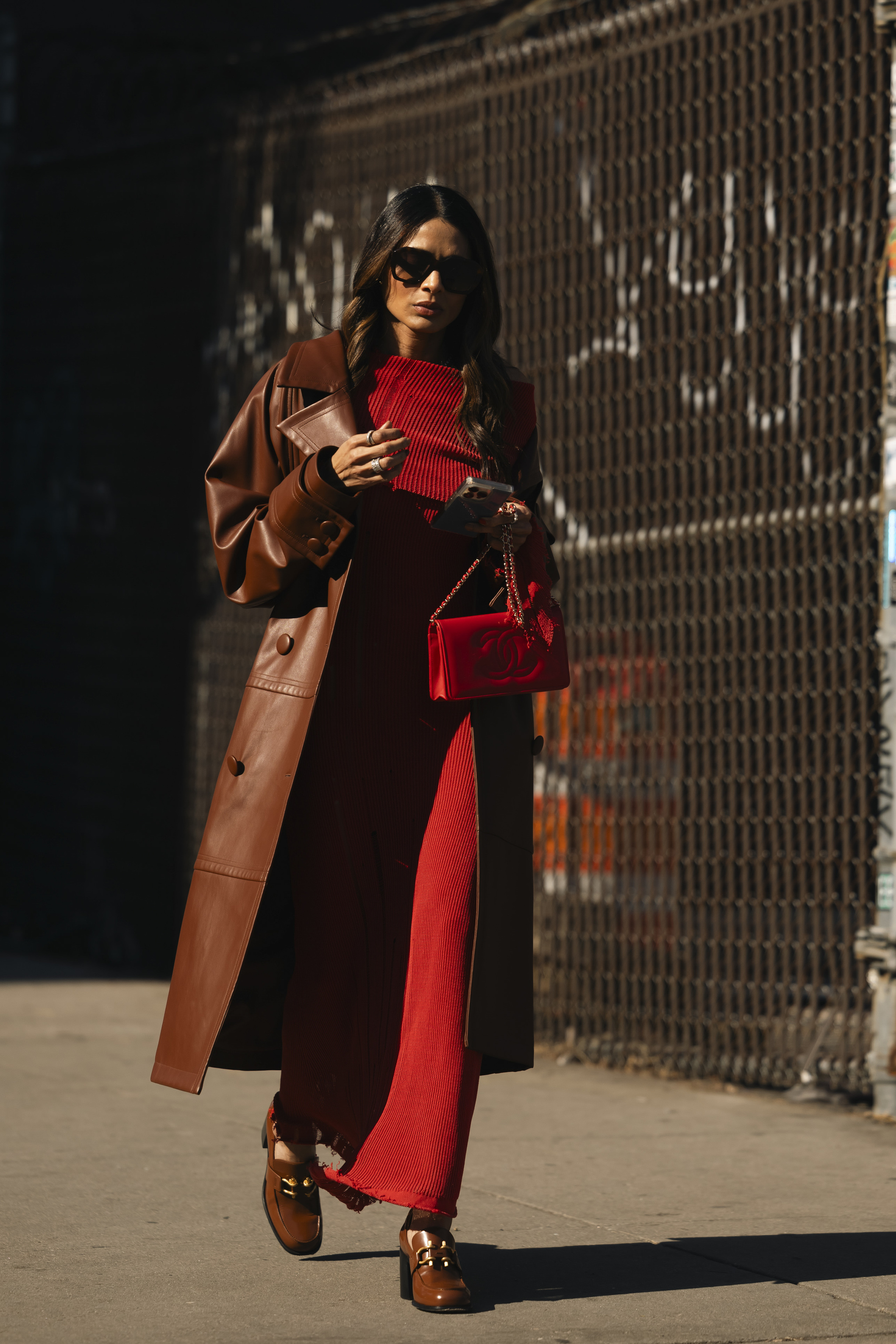 Look simple et chic à la Fashion Week de New York : trench-coat et robe en maille rouge.