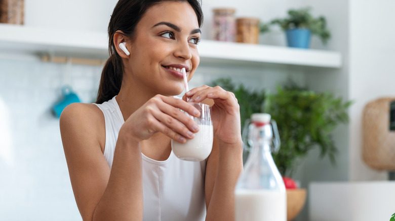 Une femme buvant du lait à travers une paille.