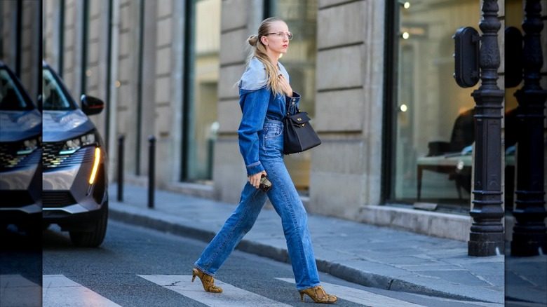 Alexandra Carl marche dans la rue dans un jean de cigarette