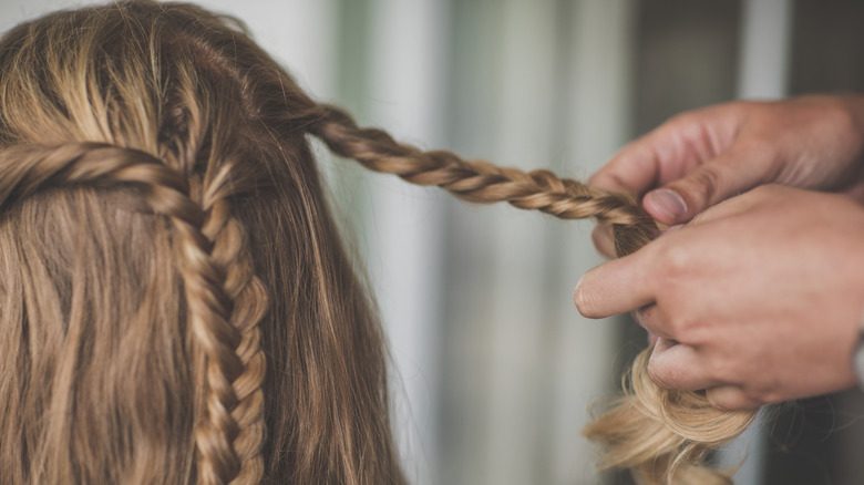 Une personne tressant les cheveux