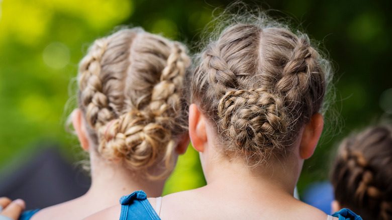 Deux femmes aux cheveux tressés en pains debout