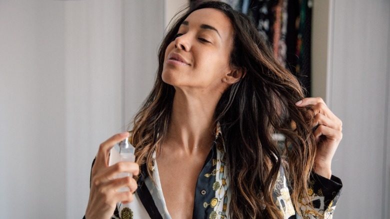 Une femme spritzing produit dans ses cheveux