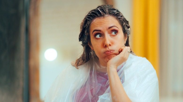 Une femme frustrée par la teinture des cheveux sur sa tête