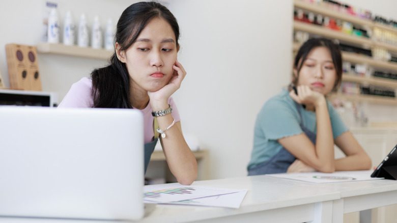 Deux propriétaires de salon regardant avec inquiétude leur ordinateur