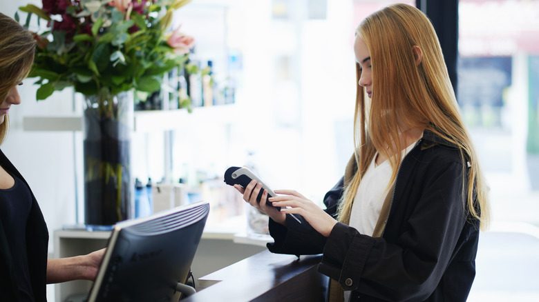 Une femme qui paie dans un salon de coiffure