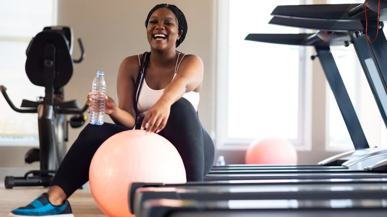 Une femme travaillant avec une balle d'exercice dans une salle de sport