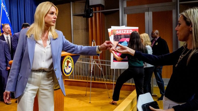 Pam Bondi portant un blazer bleu avec une chemise et un pantalon blancs