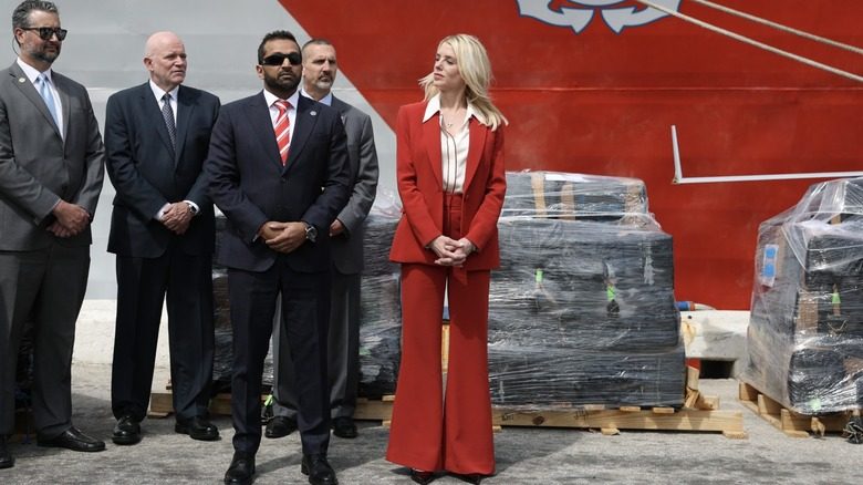 Pam Bondi portant un costume rouge avec une chemise blanche