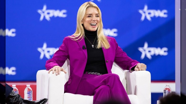 Pam Bondi portant un costume magenta et un col roulé