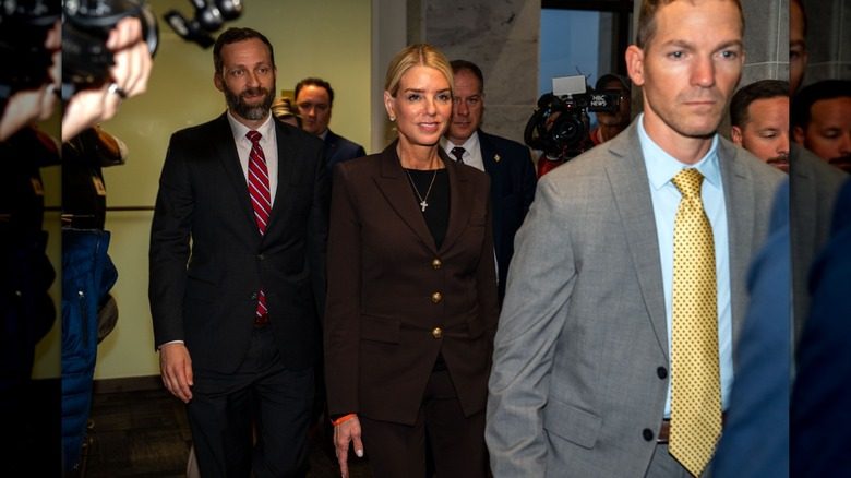 Pam Bondi portant un costume marron avec ses cheveux
