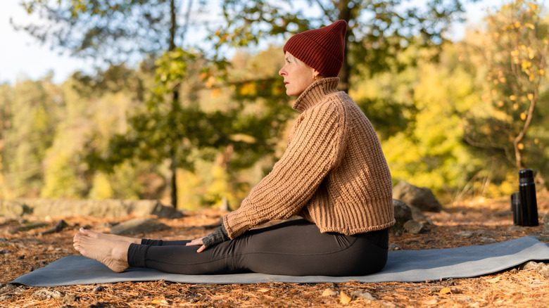 Femmes portant des leggings assis sur le tapis dans le parc pendant l'automne