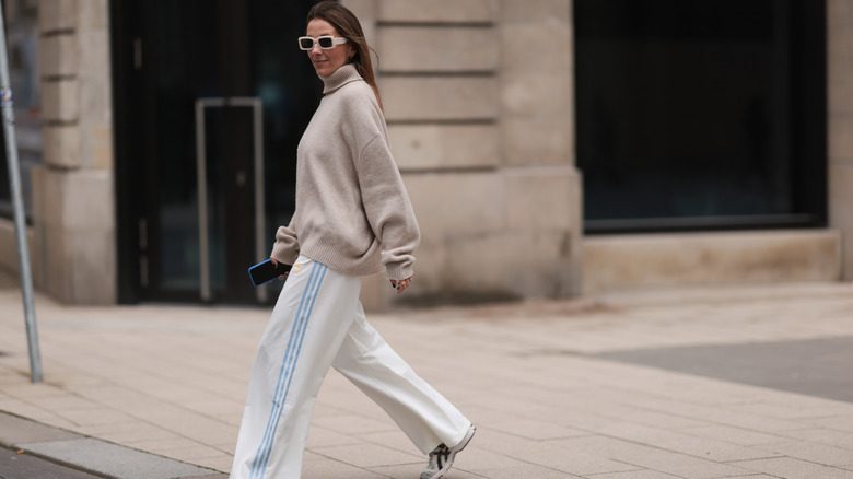 Une femme portant un pull ample et un pantalon de survêtement