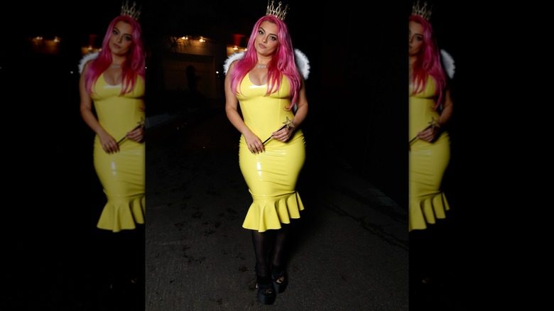 Costume d'Halloween 2025 de Bebe Rexha composé d'une robe jaune, d'ailes et d'une perruque rose