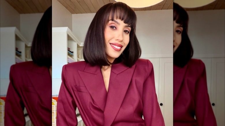 Cheryl Burke sourit dans un selfie avec une frange et une coupe de cheveux au carré