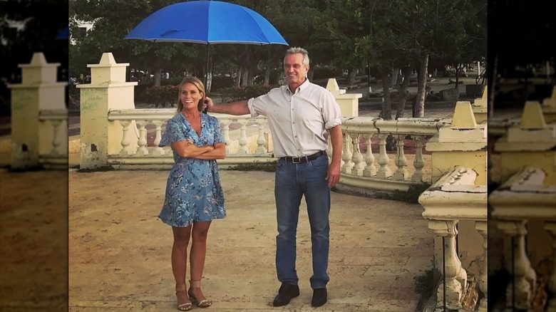 Cheryl Hines avec Robert F. Kennedy Jr. tenant un parapluie au-dessus d'elle