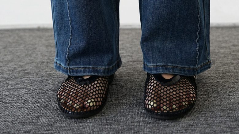 Femme en jean bleu portant des chaussures synthétiques en maille