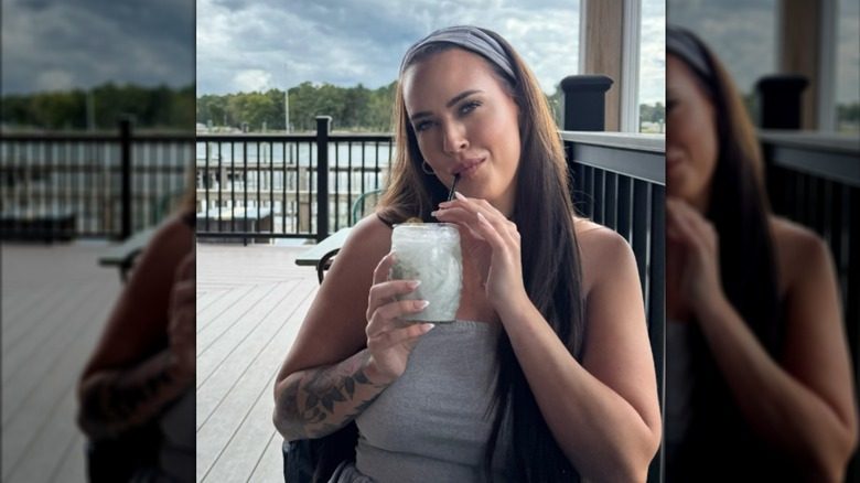 Chelsea Blackwell sirote une boisson à l'extérieur d'un restaurant