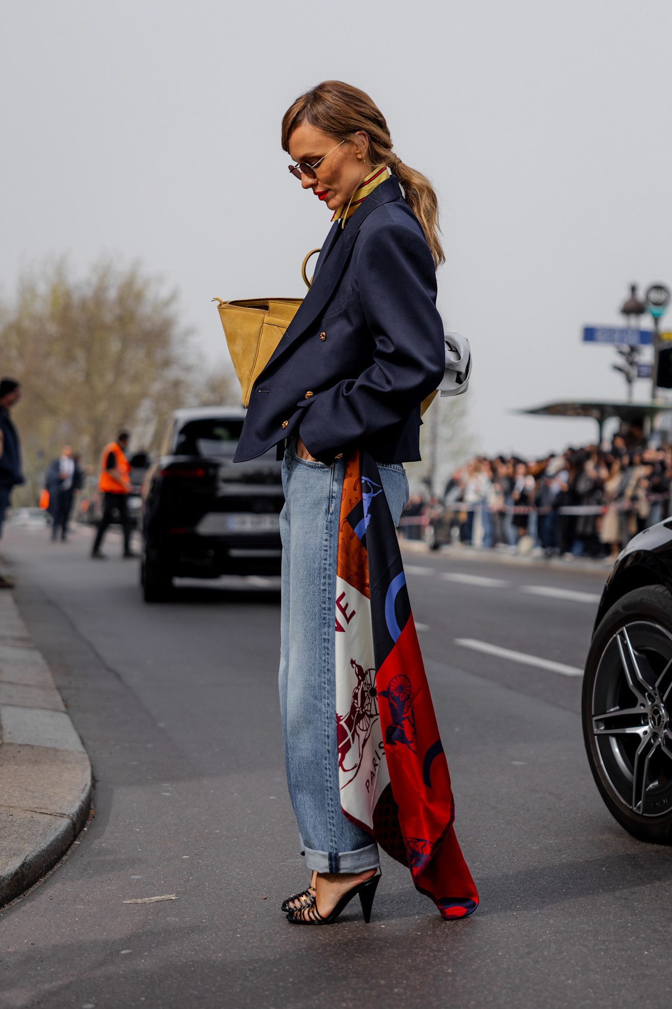 Look de jean et veste bleue avec un mouchoir noué au pantalon.