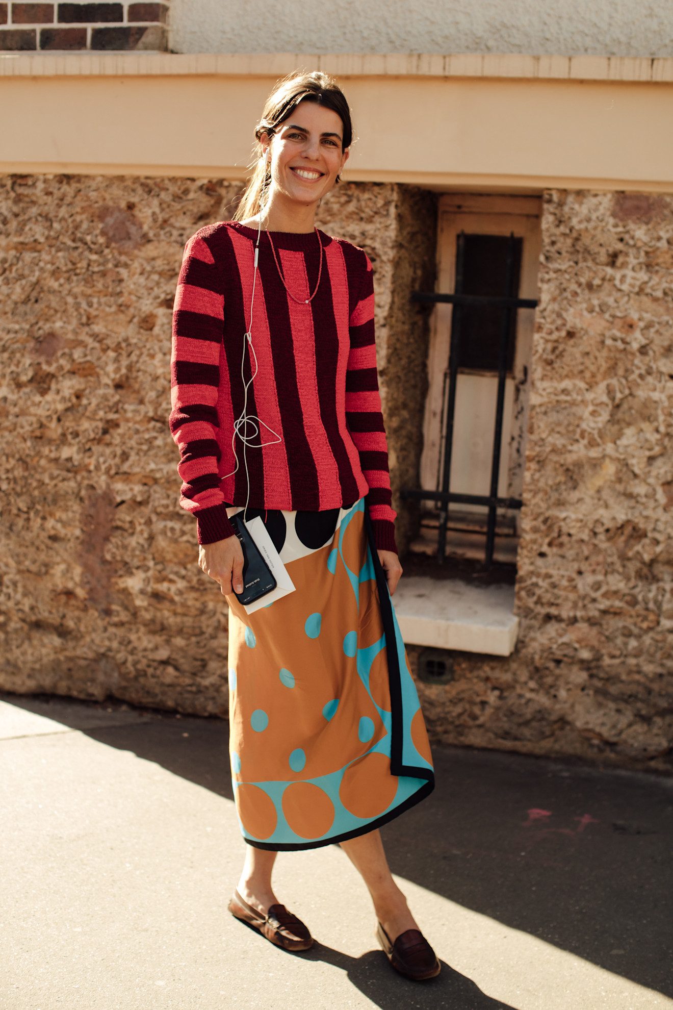 Look d'un pull rayé et d'une jupe paréo à pois avec des mocassins.