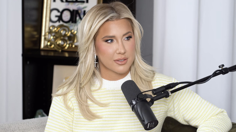 Savannah Chrisley parle dans un microphone tout en animant son podcast