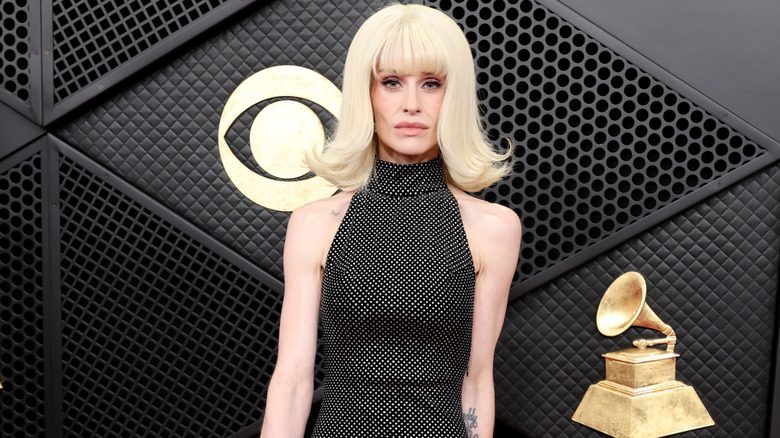 Kelly Osbourne posant dans une robe grise