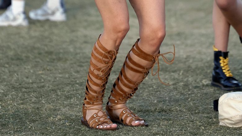 Un invité à Coachella porte des sandales spartiates marron