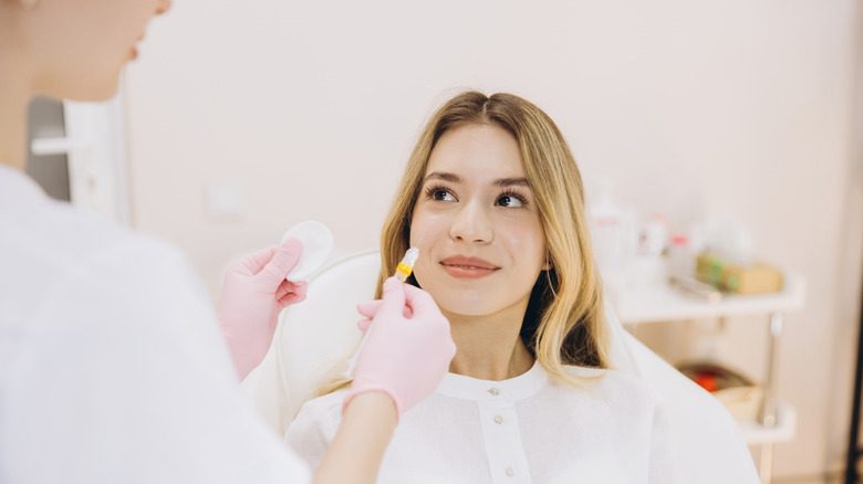 Un cosmétologue tenant une injection de botox qui est un bon substitut aux produits de comblement des lèvres