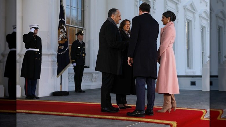 Usha Vance se présente à l'investiture présidentielle. Elle porte un long manteau rose, des gants beiges et de larges bottes beiges.