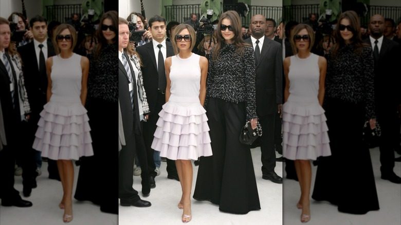 Victoria Beckham et Katie Holmes posant devant les caméras au défilé Chanel printemps-été 2007 lors de la Fashion week de Paris (2006)