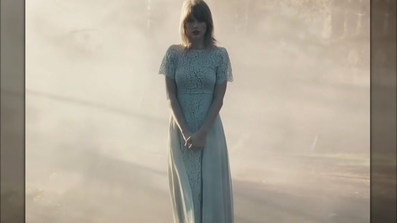 Taylor Swift est seule dans une longue robe bleu pâle à manches courtes en dentelle.