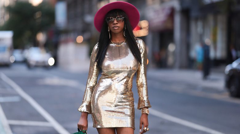 Une femme portant une robe moulante dorée brillante pour l'été