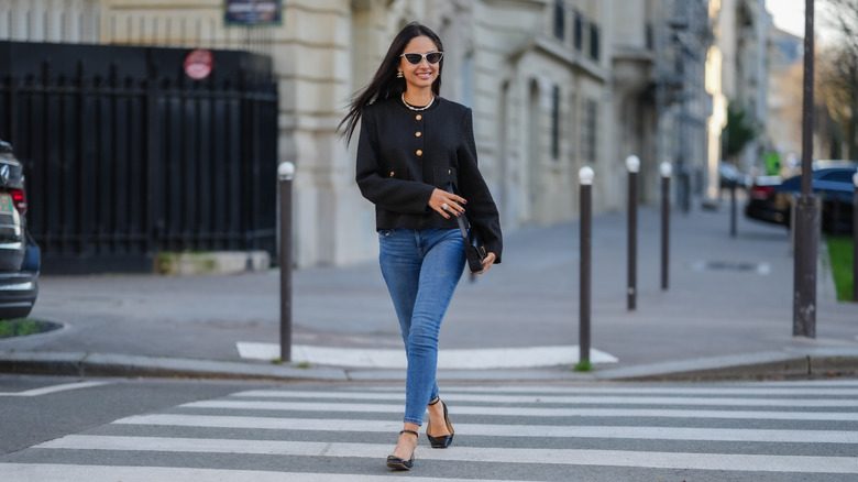 Une femme traversant la route avec un jean skinny dépassé pour l'été 2026