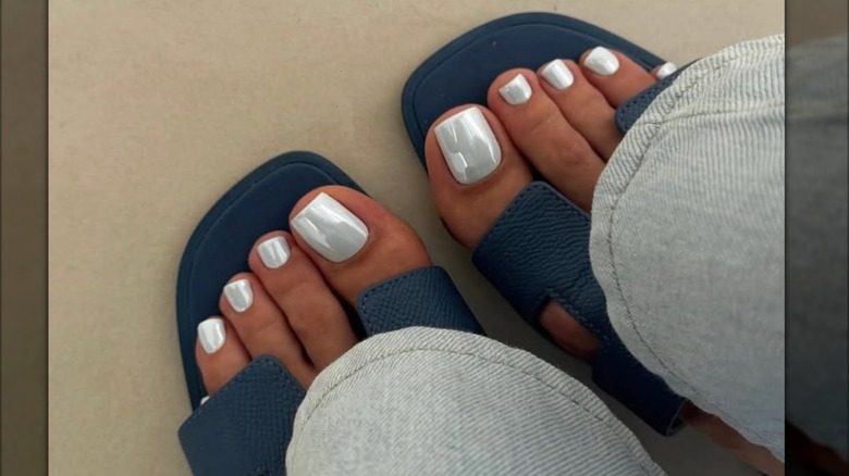 Une pédicure avec du vernis à ongles chrome argenté.