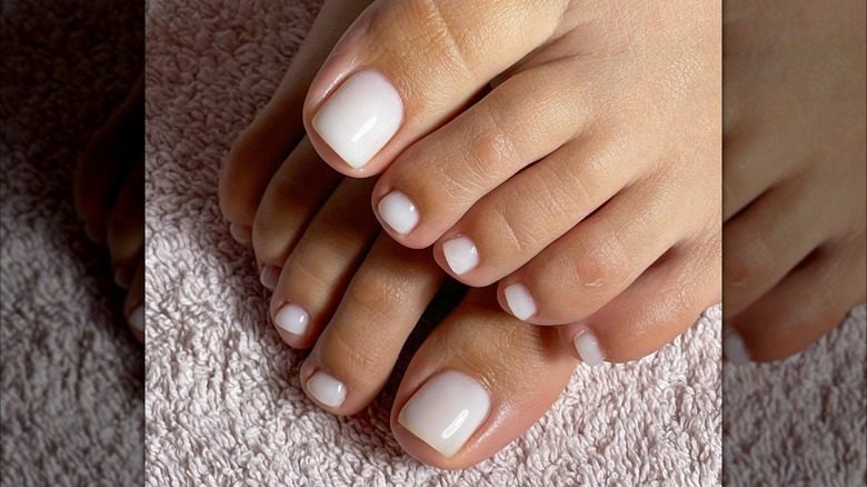 Pédicure avec vernis à ongles blanc laiteux.