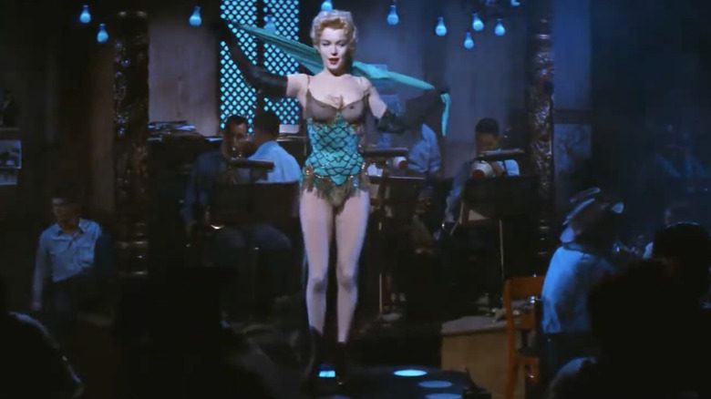 Marilyn Monroe sur scène dans un ensemble une pièce vert et noir