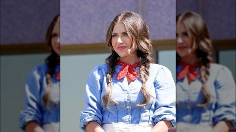 Kristi Noem se tient devant un bâtiment en costume du Sud