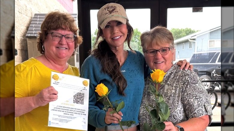 Kristi Noem est flanquée de deux amis chez un fleuriste