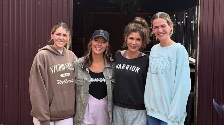 Kristi Noem pose pour une photo avec ses filles et un chignon en désordre