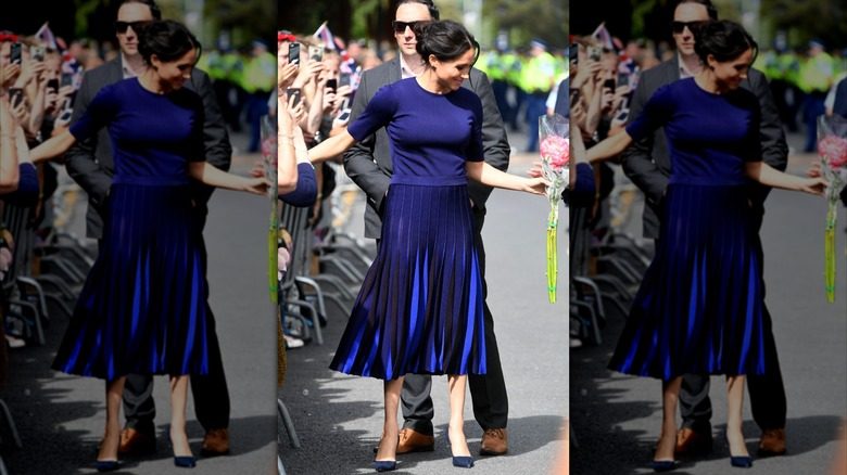 Meghan Markle porte un haut bleu royal et une jupe midi