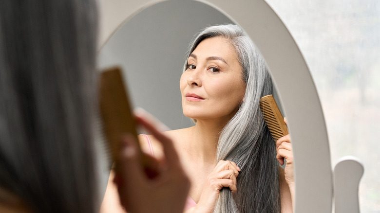 Femme se brossant les cheveux avec un peigne