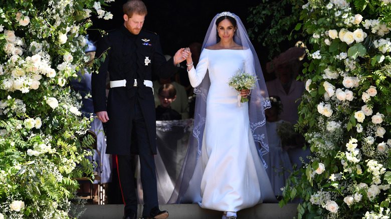 Meghan Markle photographiée avec le prince Harry portant une robe de mariée blanche à manches longues