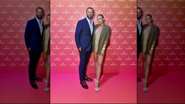 Paulina Grtezky photographiée avec Dustin Johnson portant une robe courte et un blazer