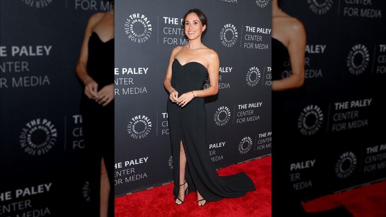 Meghan Markle portant une robe noire bustier avec des sandales à talons noires au Paley Fall Honors Gala 2024