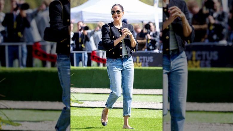 Meghan Markle porte une veste en tweed noir avec un jean légèrement délavé et des ballerines Chanel.