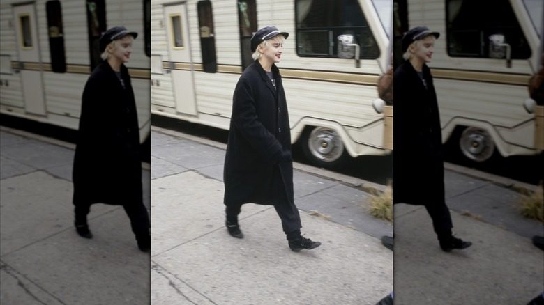 Madonna sur le tournage de "Qui est cette fille" portant un manteau noir et une casquette gavroche