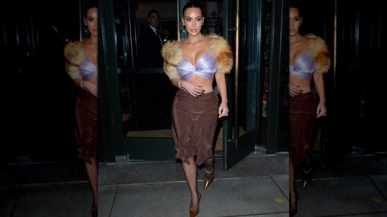 Kim Kardashian est photographiée portant un haut bordé de fourrure lilas et une jupe marron à New York en 2025.