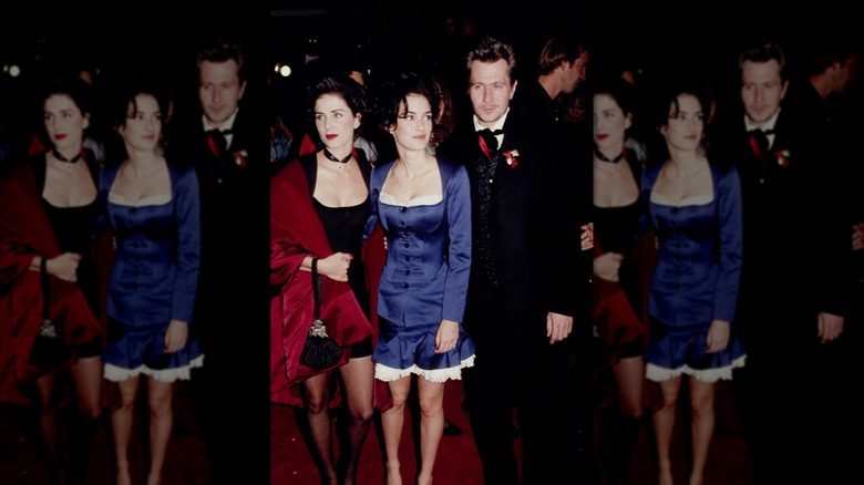 Winona Ryder dans une robe bleue debout avec ses co-stars de Dracula lors d'un événement sur le tapis rouge.